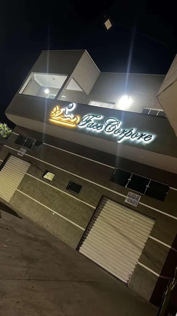 Fachada da Face Corpore iluminada à noite, com letreiro em neon